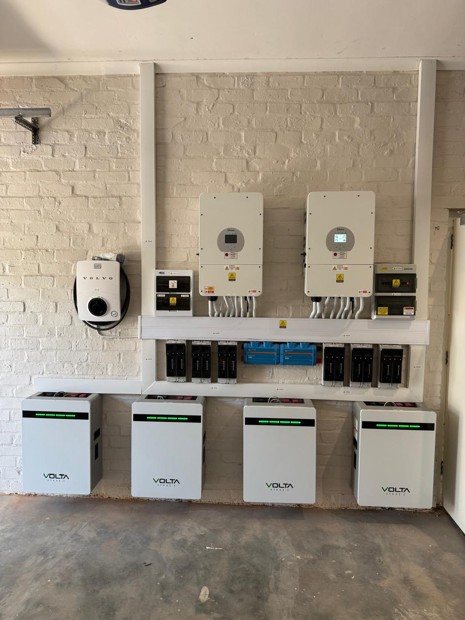 Two wall-mounted Deye inverters, four Volta batteries and a Volvo electric vehicle charger