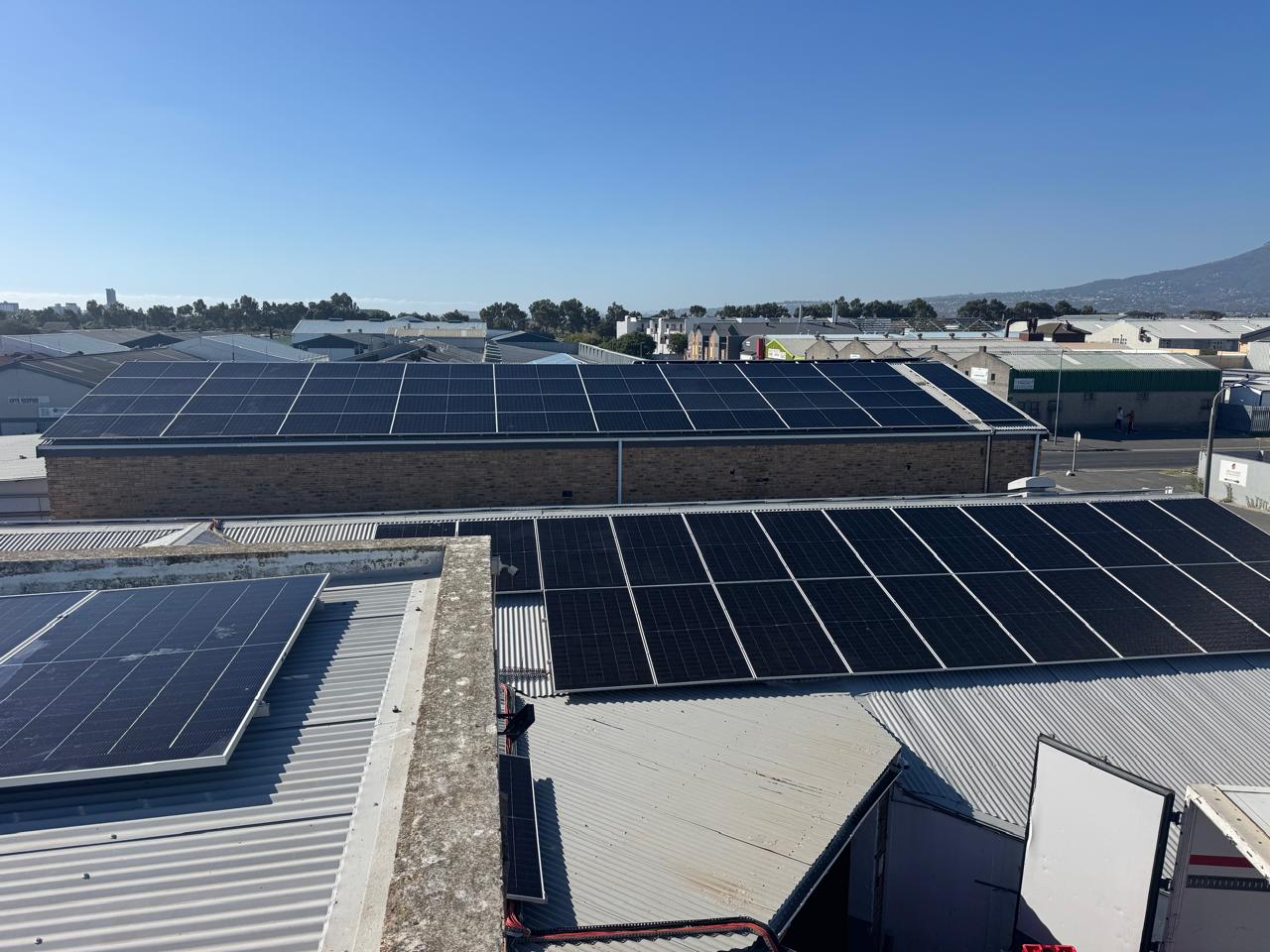 Solar panel arrays across multiple adjoining commercial roofs