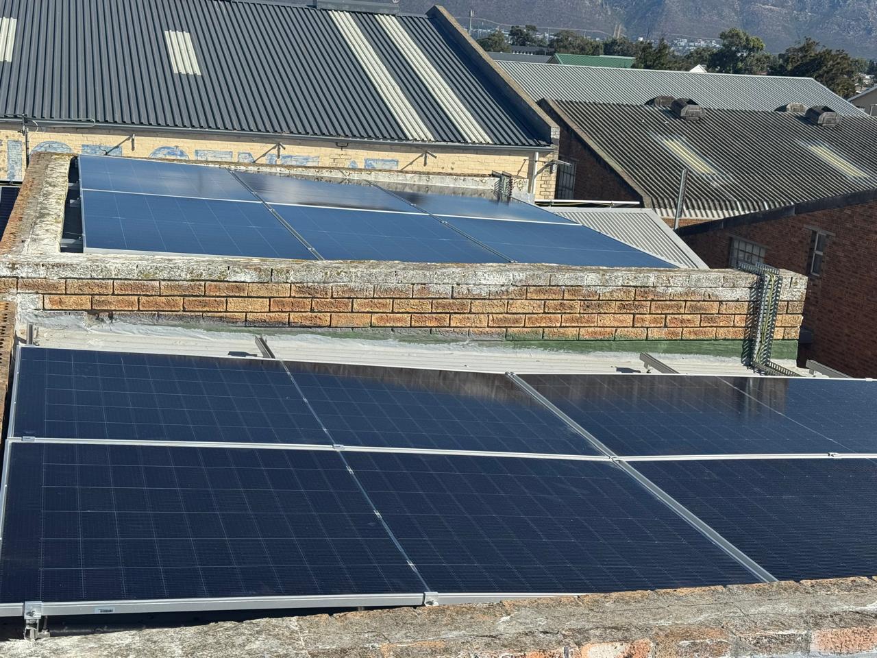 Solar panels installed across several roof sections and parapets